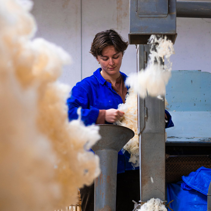 Matelassière travaillant la laine de mouton à l’atelier