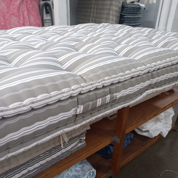 Matelas en laine rayé beige dans l'atelier
