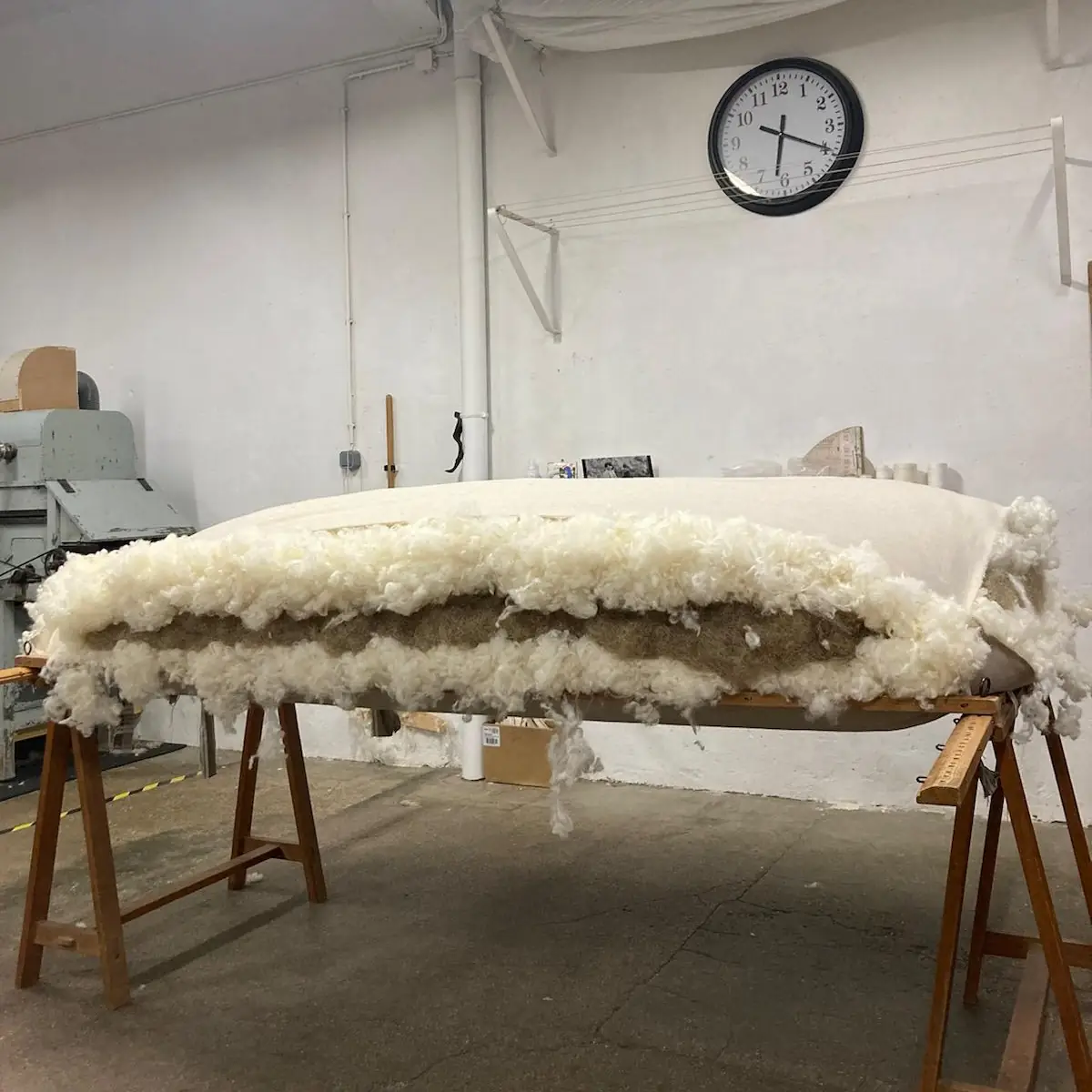 Matelas en laine et crin en cours d’ouverture sur tréteaux, à l’atelier Le Briand