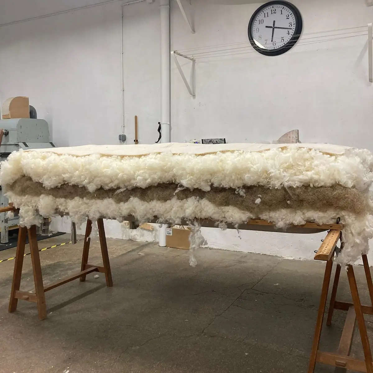 Coupe d’un matelas en laine et crin à l’atelier : laine de mouton, âme en crin, laine de mouton